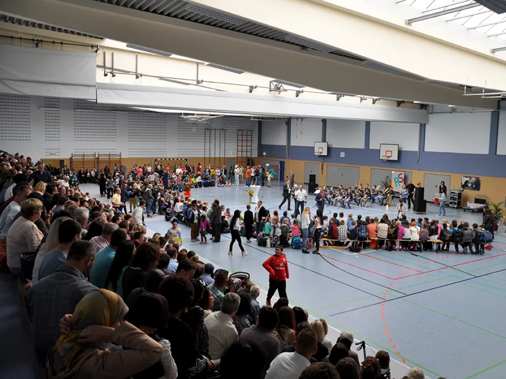 Blick über die sitzenden Gäste in der Sporthalle.